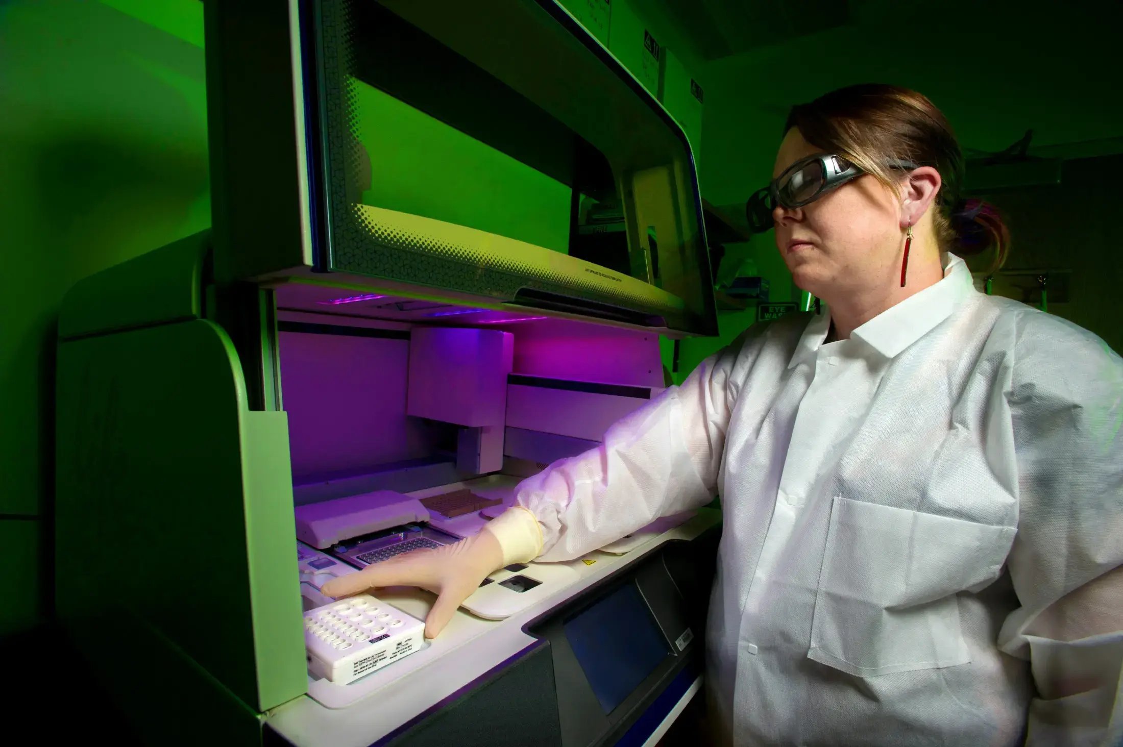 one of Cmbios lab workers amending the position of a sampling kit within a regulated environment machine